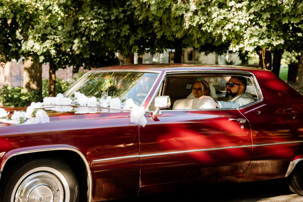 Brautpaar fotografiert in einem Cadillac Brautauto