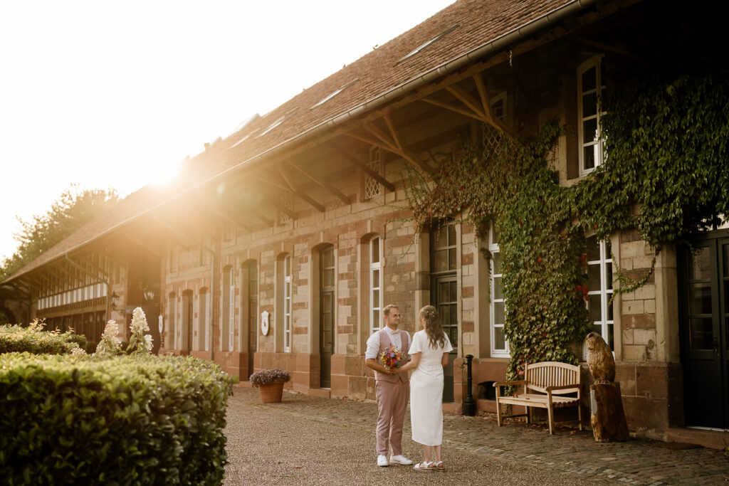 Brautpaar am Linsler Hof bei Sonnenuntergang steht sich gegenüber