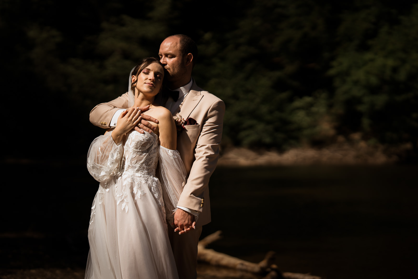 Brautpaarfoto im harten Sonnenlicht. Beide schließen die Augen, der Hintergrund ist durch den Kontrast stark abgedunkelt