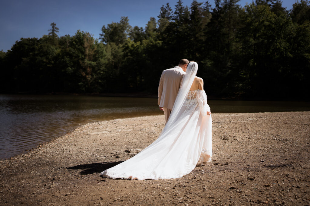 Brautpaar spaziert in Mittagssonne am Wasser - authentische Hochzeitsreportage im Saarland