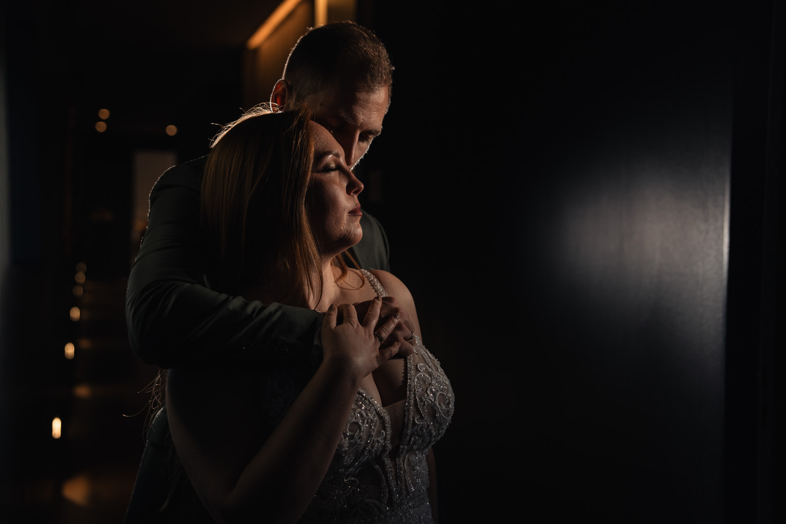 foto eines brautpaares vor einer dunklen wand