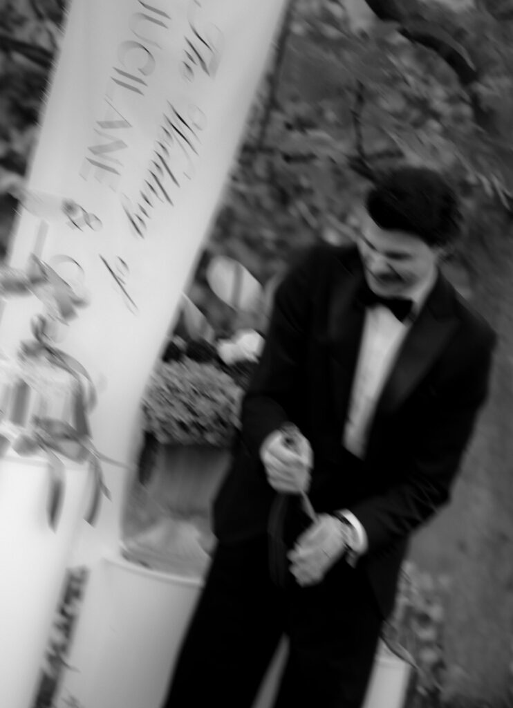 Bräutigam öffnet Champagnerflasche während der Hochzeitsparty