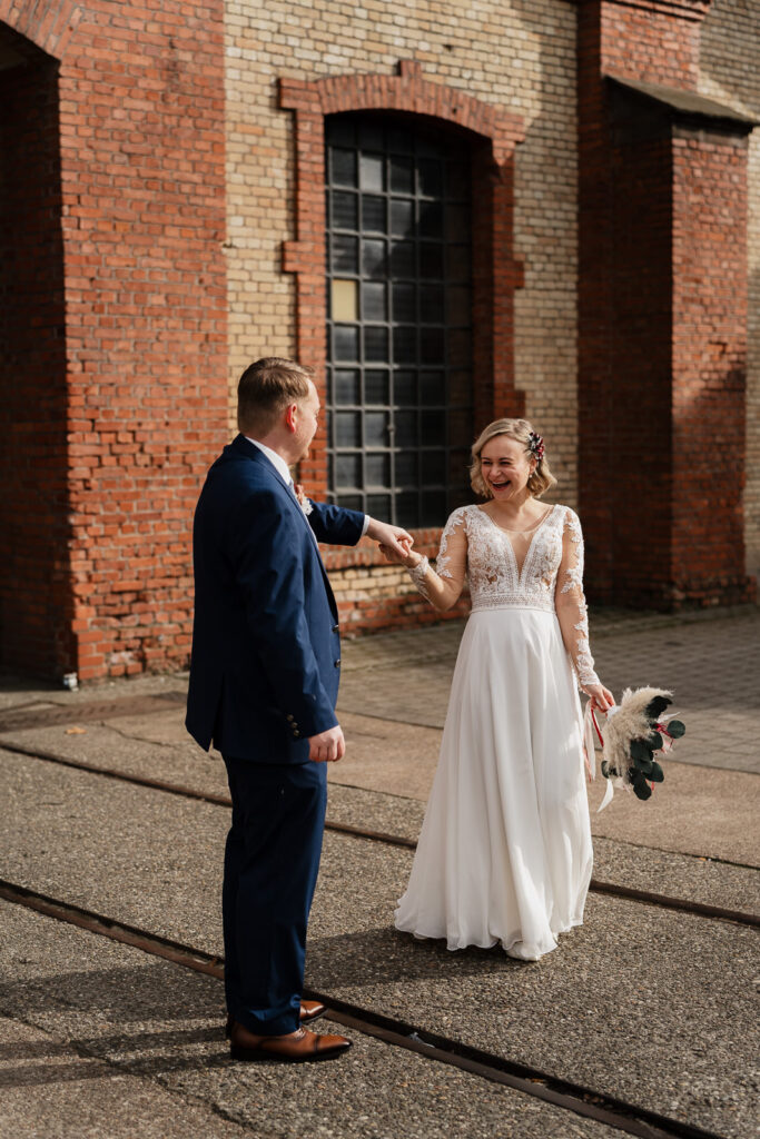 Brautpaar tanzt vor einer alten Industriehalle