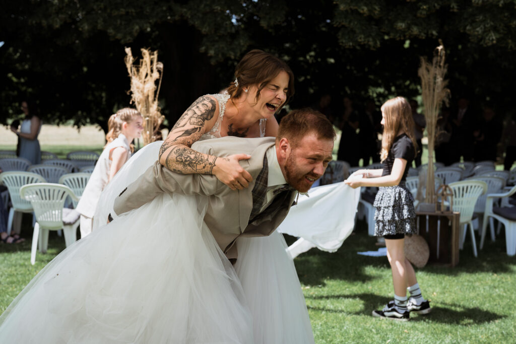 Bräutigam trägt seine Braut auf seinem Rücken