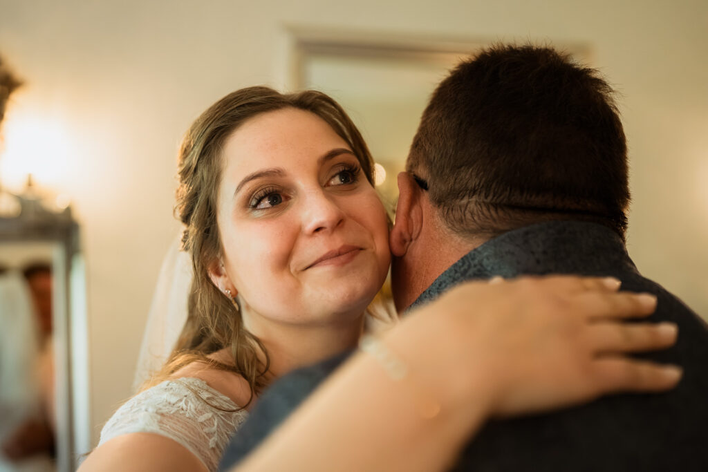 Braut hat Tränen in den Augen, während sie ihren Vater umarmt
