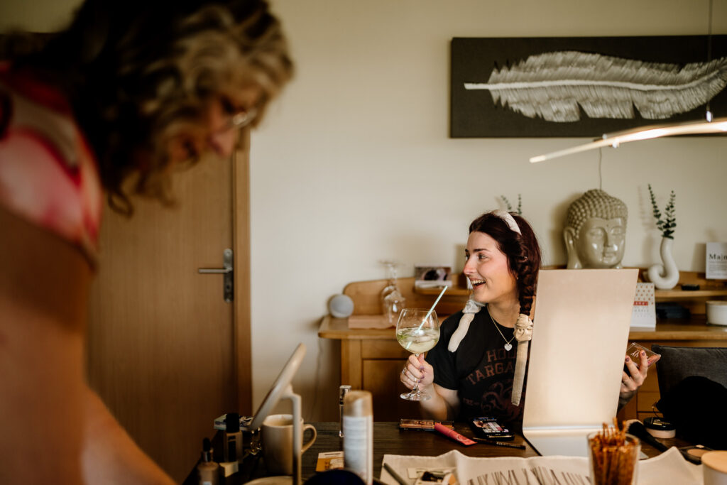 Braut beim Getting Ready trinkt einen Cocktail