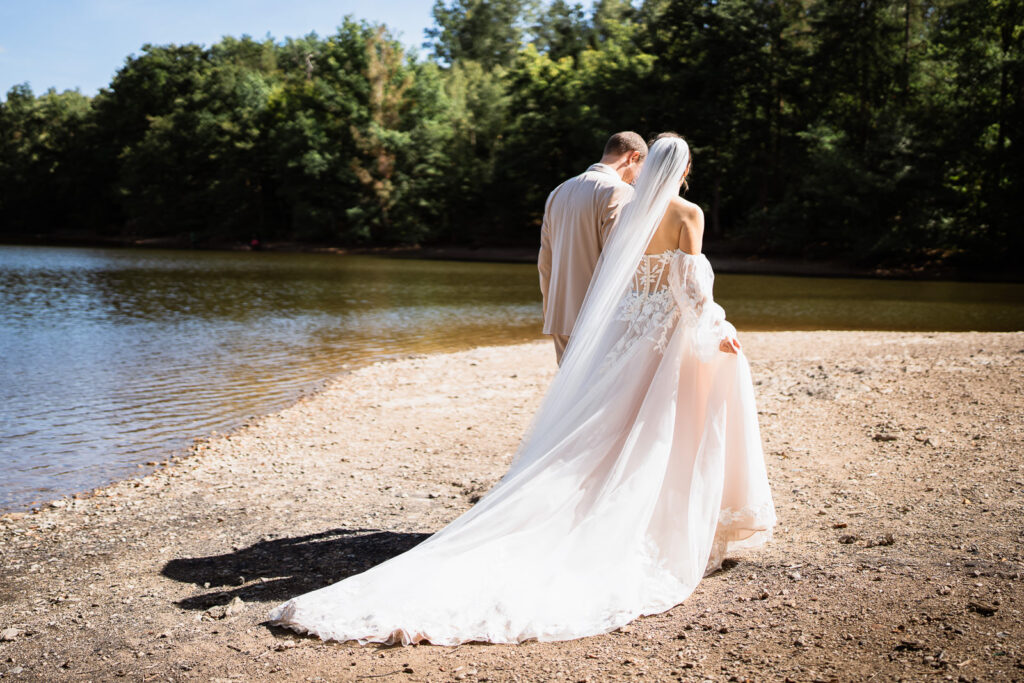 Brautpaarshooting Saarland am Itzenplitzer Weiher im harten Mittagslicht. Brautpaar geht von der Kamera weg
