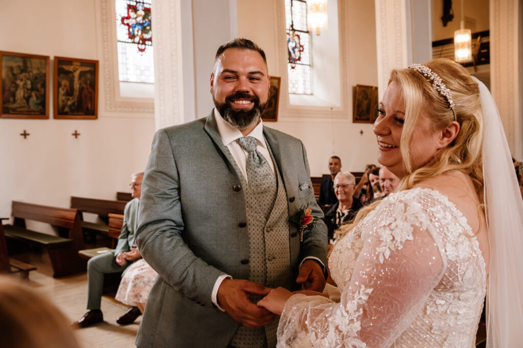 Kirchliche Hochzeit Saarland. Bräutigam lächelt zu Fotografin