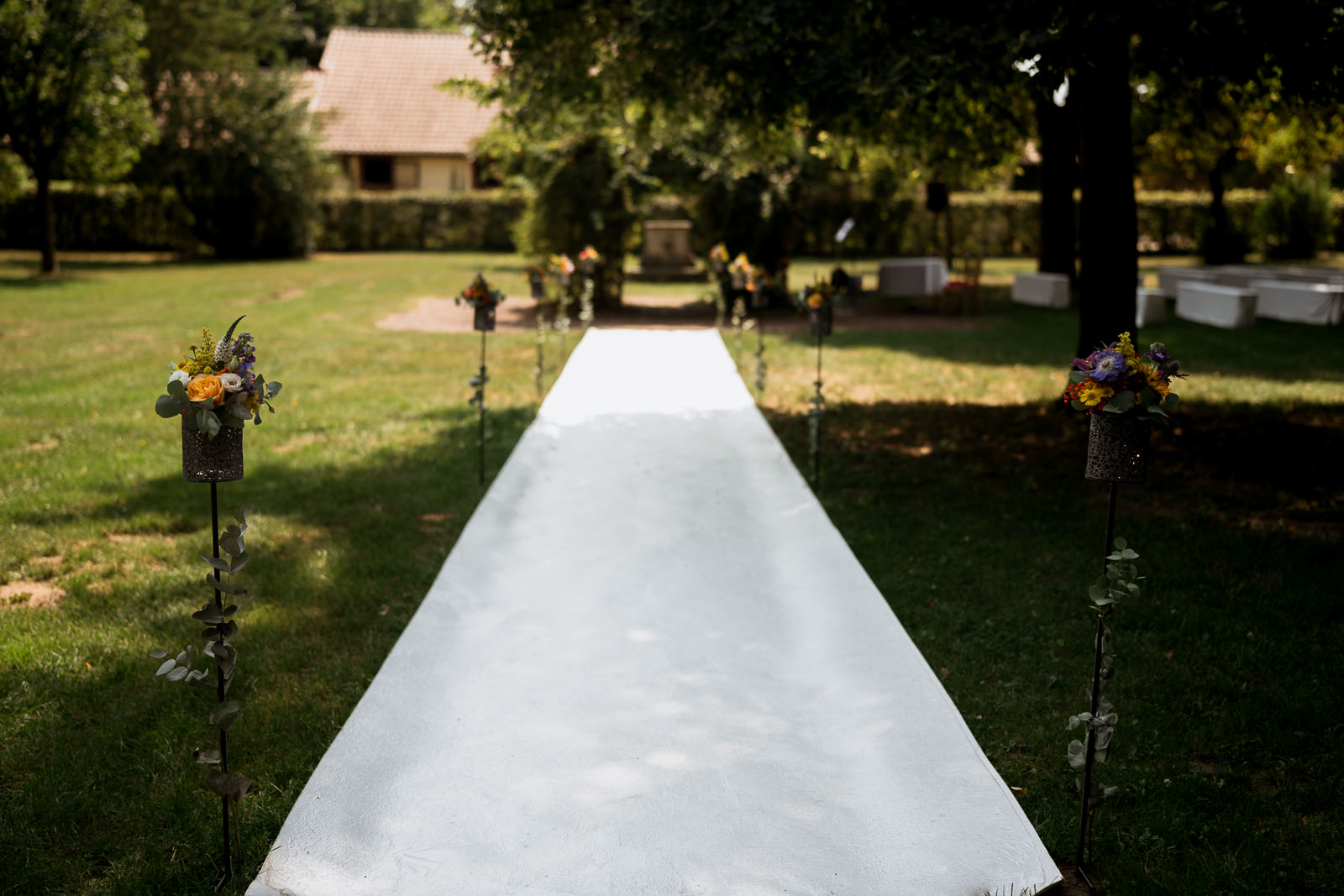 Langer weißer Teppich führt draußen zu einem Traubogen am Linsler Hof