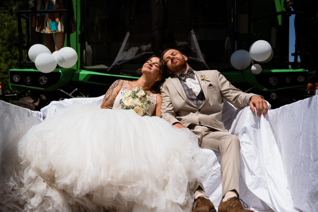 Brautpaar im harten Licht sitzt auf einem Sofa, das sich auf einem Mähdrescher befindet