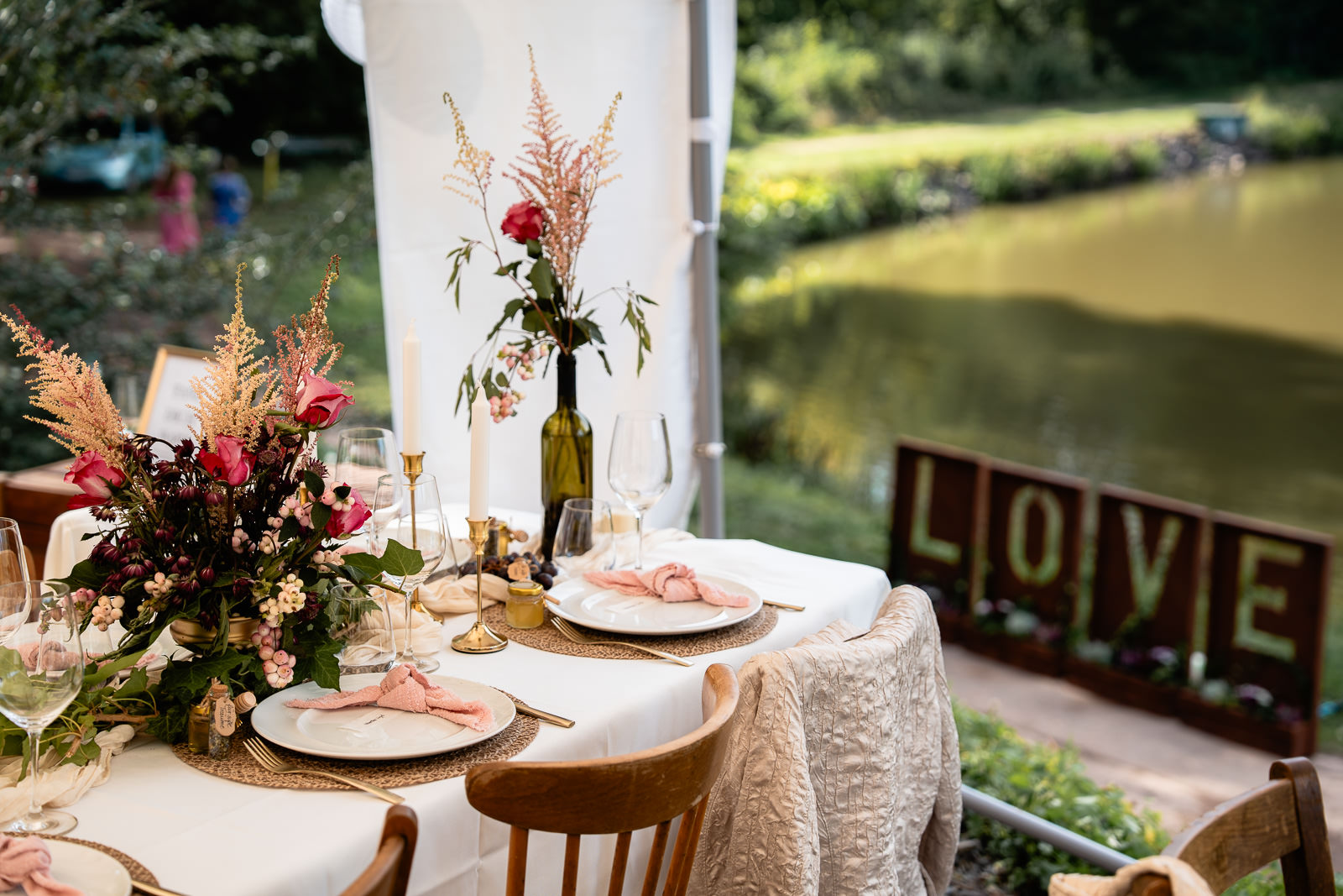 Festliche Dekoration eines Tisches. Im Hintergrund Schriftzug "Love" und Weiher