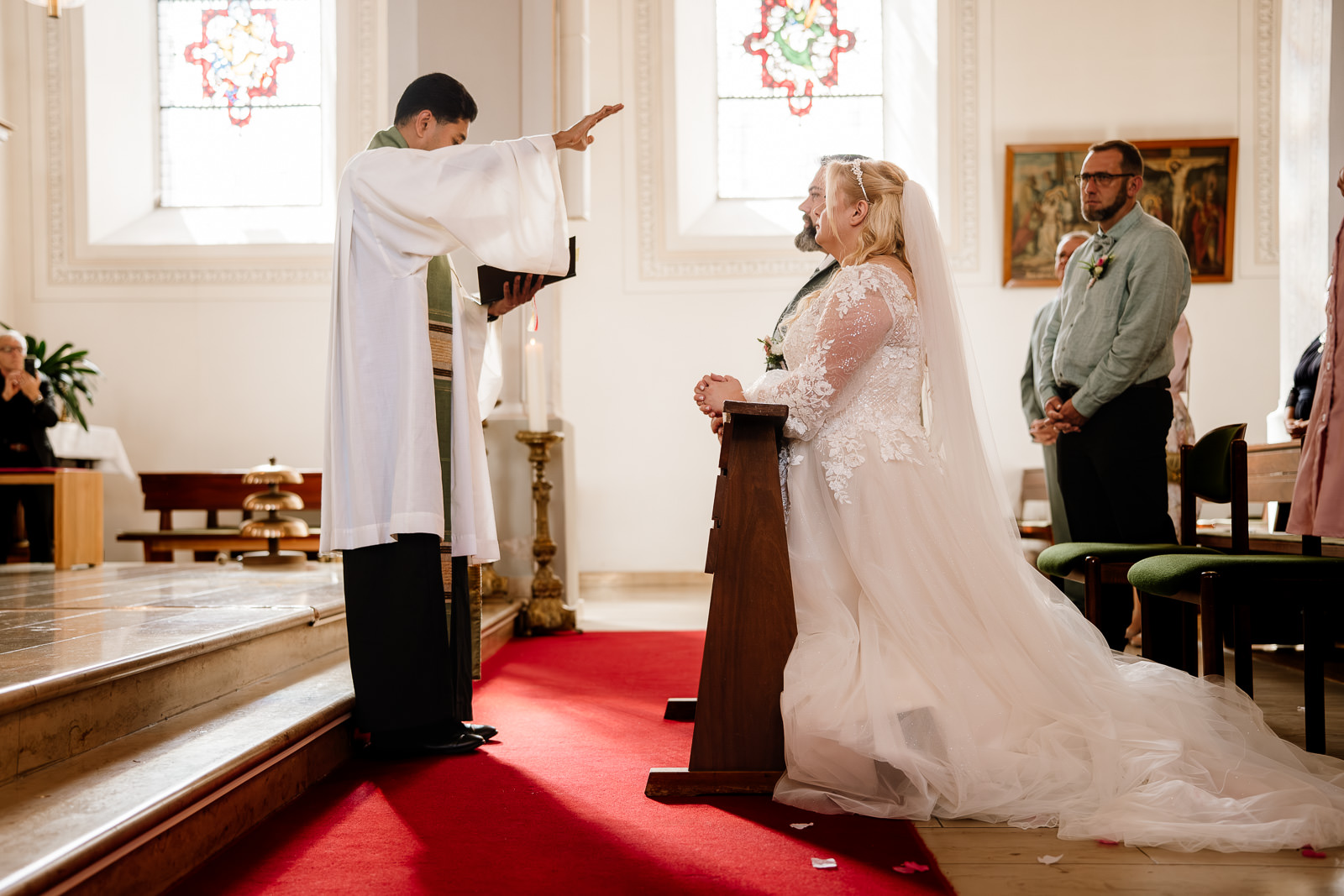 Brautpaar erhält Segen bei kirchlicher Hochzeit. Fotograf hält Moment fest