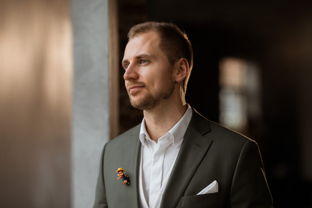 Bräutigam schaut aus dem Fenster, seitliches Licht auf dem Gesicht