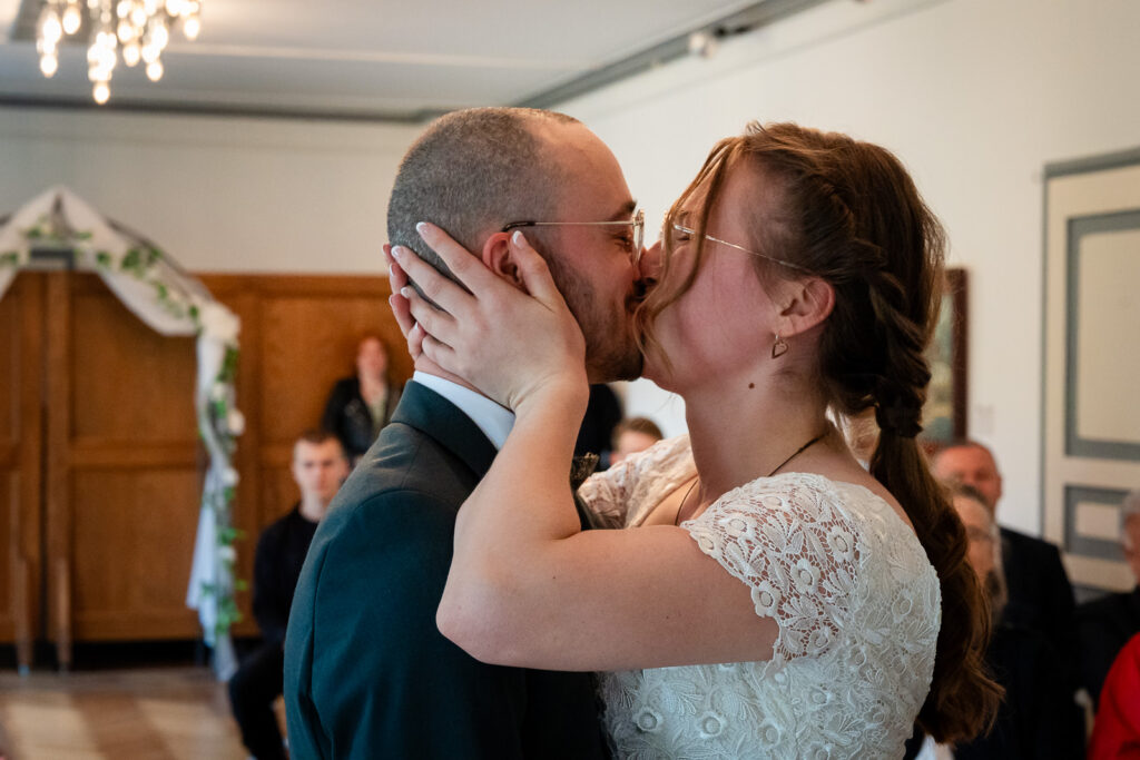 Brautpaar küsst sich im Standesamt