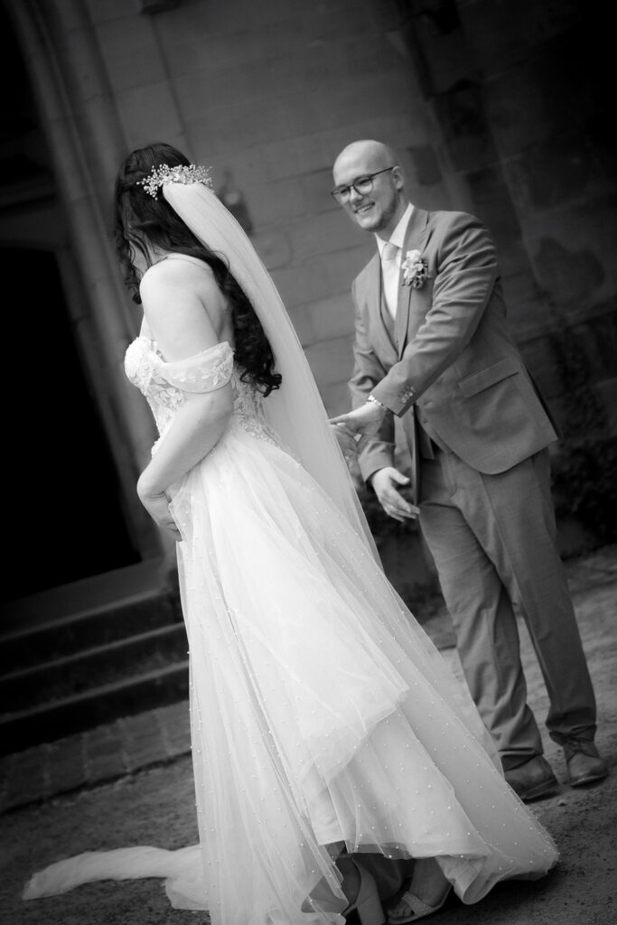 Braut und Bräutigam halten sich an der Hand und schauen sich an