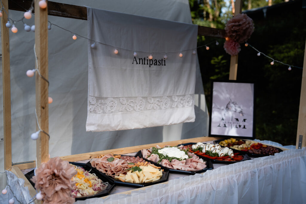 Marktstand auf einer Hochzeit mit dem schriftlichen Hinweis Antipasti. Das Antipaste wurde auf Platten angerichtet.