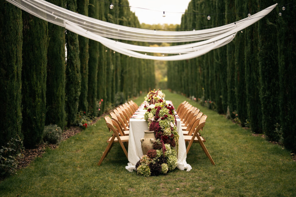 Gedeckter Hochzeitstisch mit mediterraner Tischdekoration und Blumenarrangement