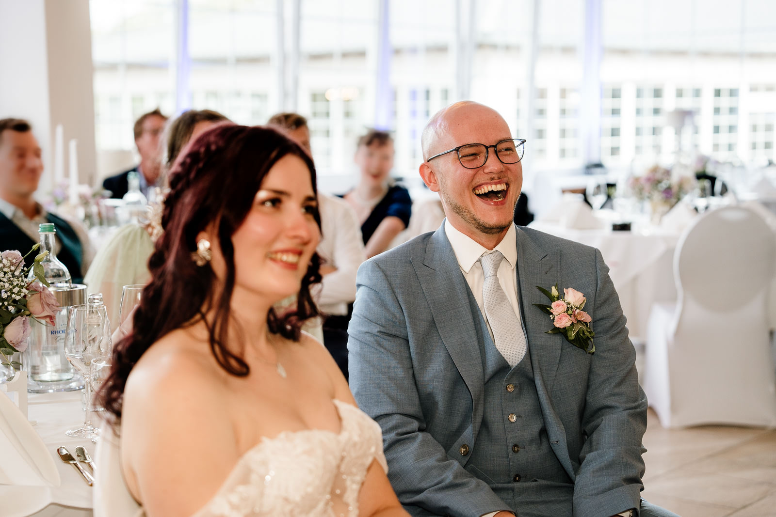 Brautpaar in Festsaal. Bräutigam lacht