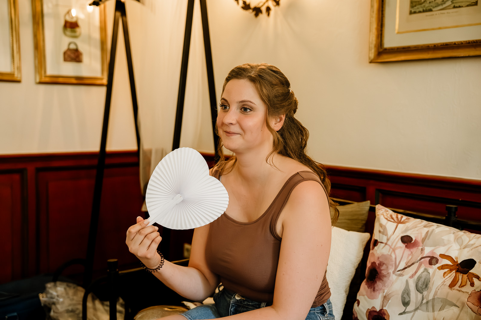 Frau fächert sich mit Herzfächer Luft zu