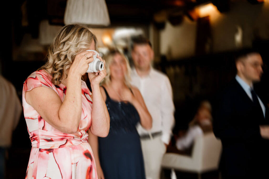 Hochzeitsfotograf Saarland hält Szene mit Frau mit einer Sofortbildkamera fest