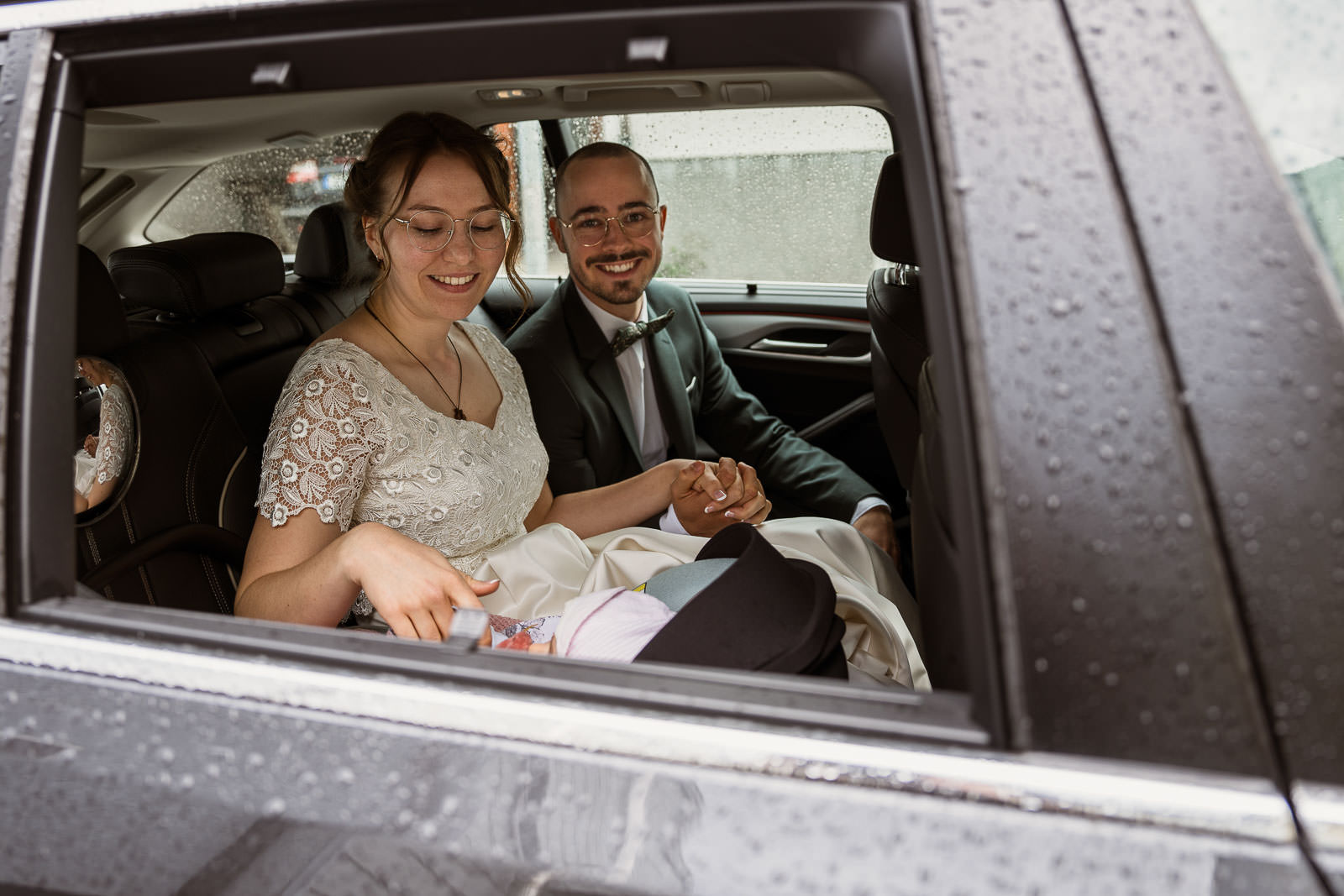 hochzeit bei regen mit Brautpaar im Auto