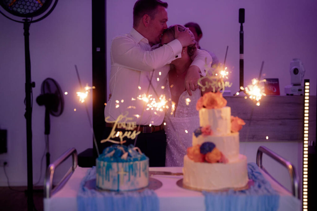 Im Vordergrund Hochzeitstorte und Tauftorte, im Hintergrund Brautpaar